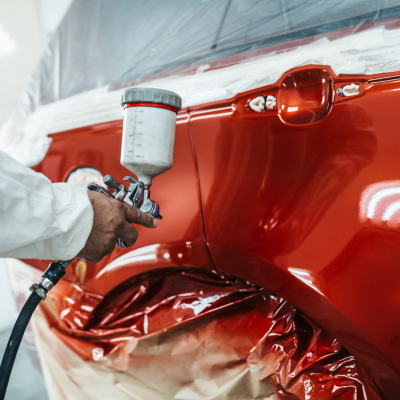 Applying paint by sprayer to a car