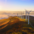 On-shore wind turbines operating in a rural environment under clear skies, showcasing corrosion protection.