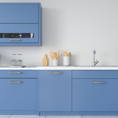 A contemporary kitchen featuring blue cabinets with gold handles, a white countertop, and a minimalist backsplash.