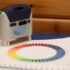 A spectrophotometer placed on a colour reference guide to measure and digitally match paint shades.