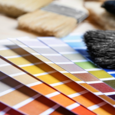 A selection of colourful paint swatches laid out alongside paintbrushes for choosing the right shade.